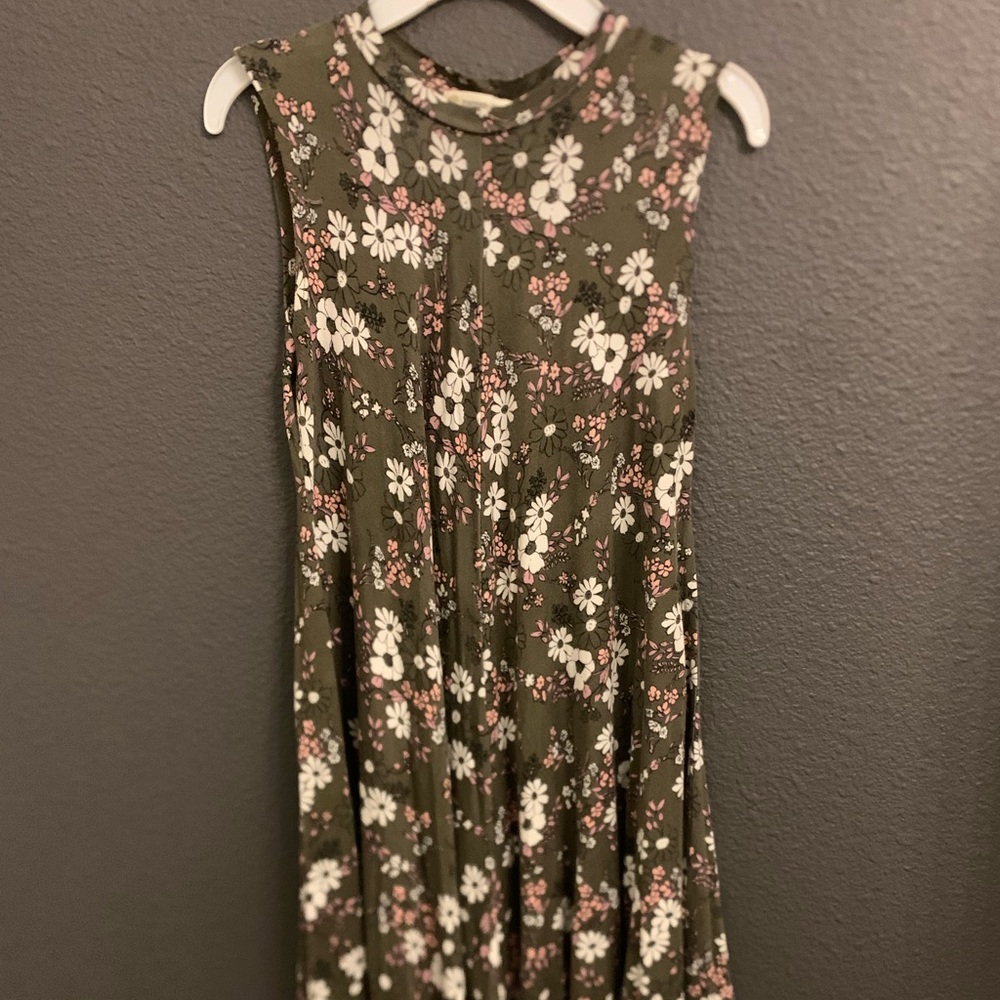 A beautiful dark green dress with white and pink flowers decorated around it.